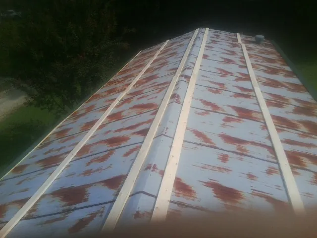 Rusted metal roof panels with new wood purlins before replacement — Storm Damage Roof Repair in Clarissa by Roofing Brothers