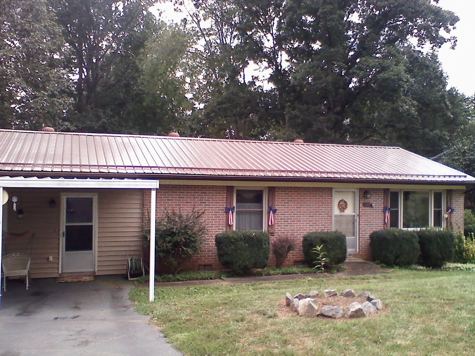 Bronze metal roof and carport on a brick ranch home — Roof Repair work by our crew in Clarissa